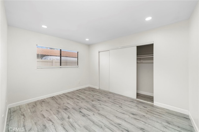 unfurnished bedroom featuring a closet and light hardwood / wood-style floors