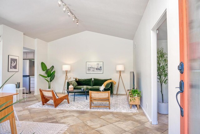 living room with lofted ceiling and rail lighting