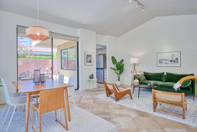 living room with vaulted ceiling and rail lighting