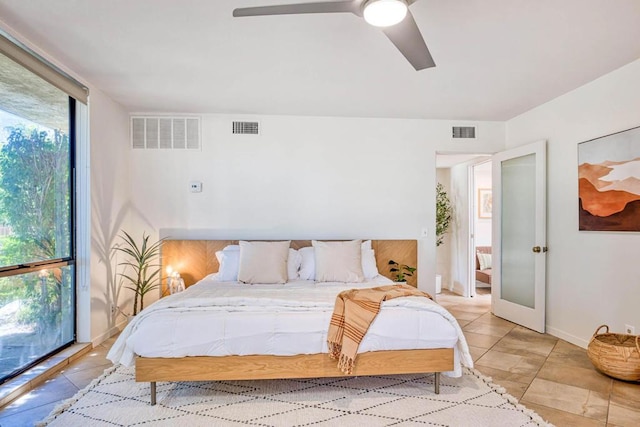 tiled bedroom with floor to ceiling windows and ceiling fan