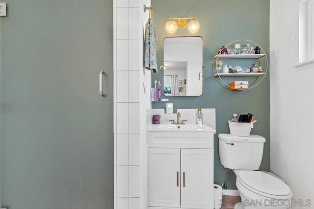 bathroom with tile patterned floors, vanity, toilet, and a shower with shower door