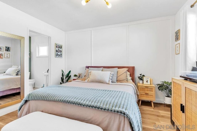 bedroom featuring light hardwood / wood-style flooring and ensuite bath