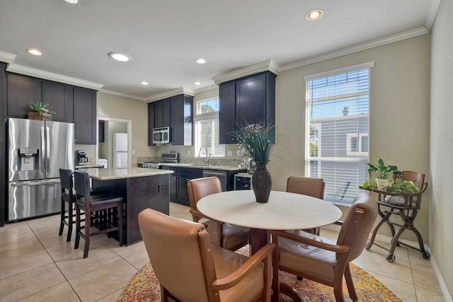 kitchen with stainless steel appliances, light stone countertops, a kitchen island, and light tile patterned floors