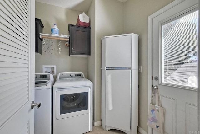 washroom featuring cabinets and washer and clothes dryer