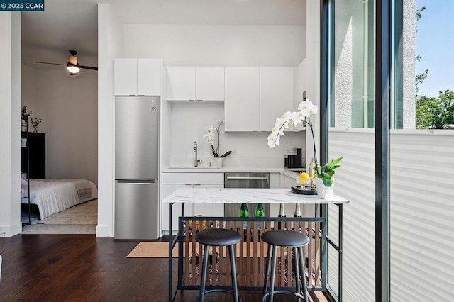 kitchen featuring ceiling fan, dark hardwood / wood-style floors, sink, white cabinetry, and appliances with stainless steel finishes