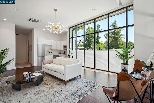 living room with a healthy amount of sunlight, a wall of windows, and hardwood / wood-style flooring