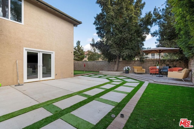 view of yard with a patio area, an outdoor living space, and french doors