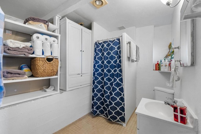 bathroom with curtained shower, toilet, and vanity