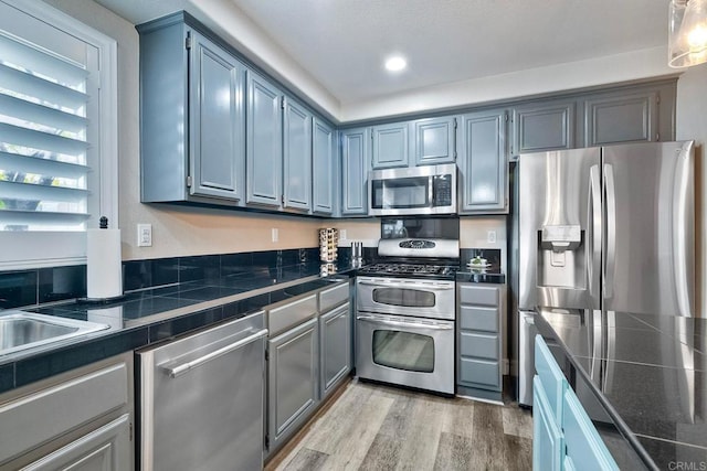 kitchen with light hardwood / wood-style flooring and appliances with stainless steel finishes