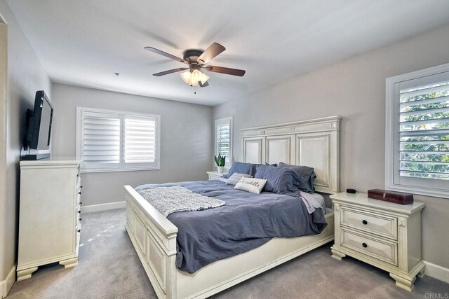 bedroom featuring multiple windows, light carpet, and ceiling fan