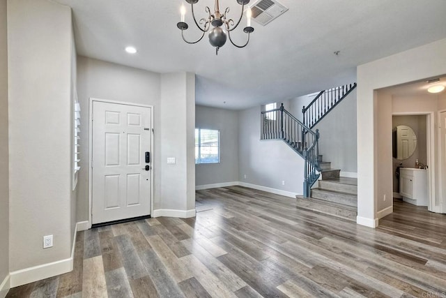 foyer with wood-type flooring and a chandelier