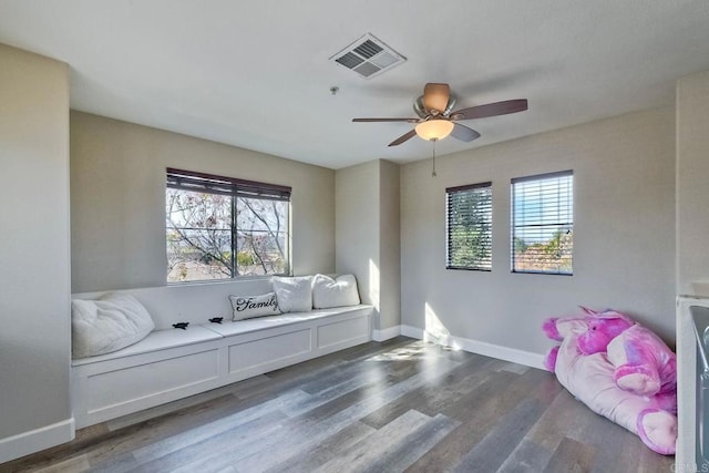 sitting room with dark wood-type flooring and ceiling fan