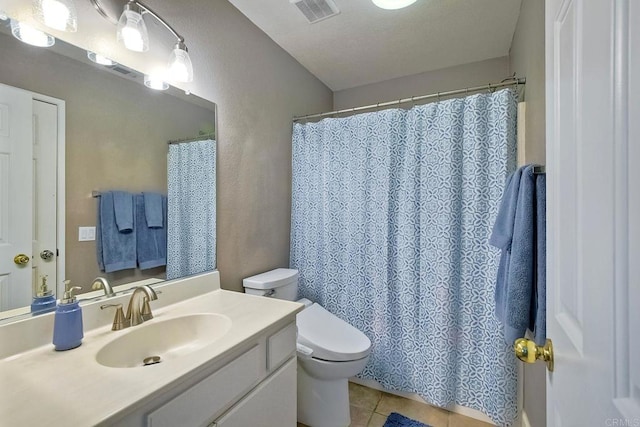 bathroom featuring tile patterned flooring, vanity, and toilet