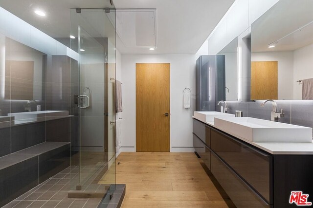 bathroom with walk in shower, backsplash, and vanity