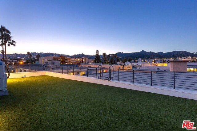 surrounding community with a lawn and a mountain view