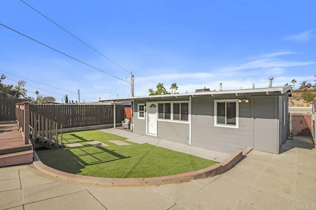 back of property featuring a wooden deck and a lawn