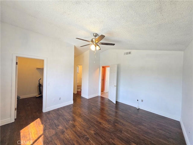 spare room with vaulted ceiling, ceiling fan, dark hardwood / wood-style flooring, and a textured ceiling