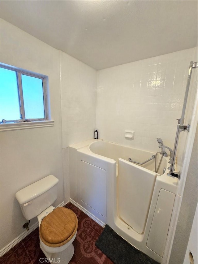 bathroom with toilet, a bathing tub, and tile patterned floors