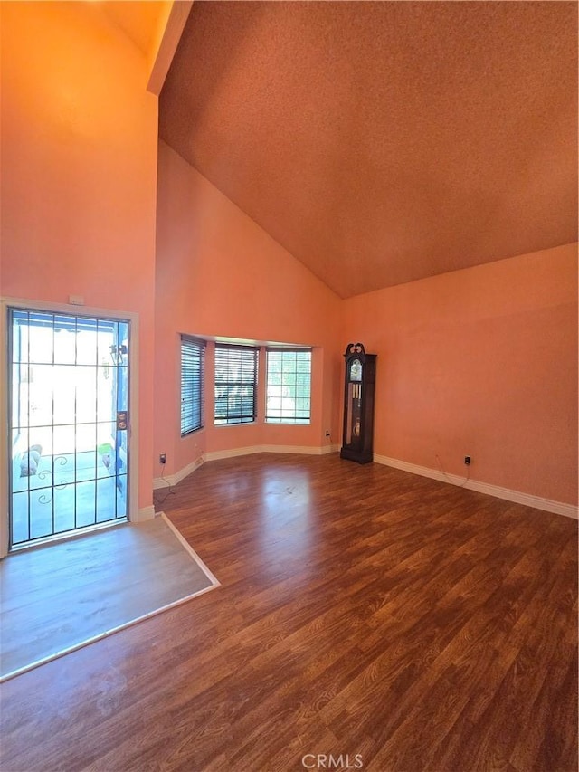 unfurnished living room with hardwood / wood-style flooring and high vaulted ceiling