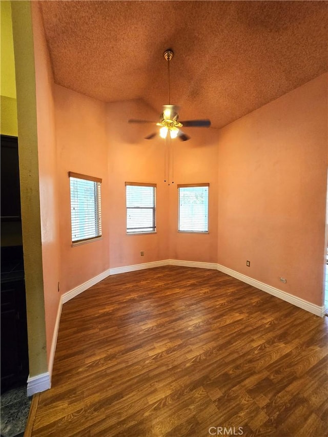 unfurnished room with ceiling fan, dark wood-type flooring, and a textured ceiling