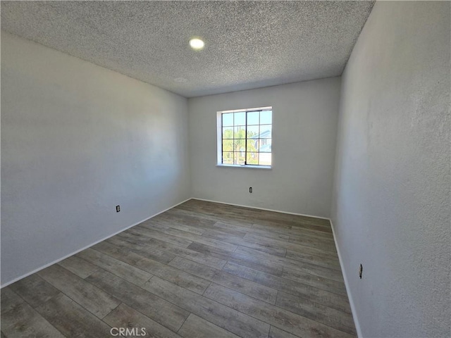 unfurnished room featuring a textured ceiling and hardwood / wood-style floors