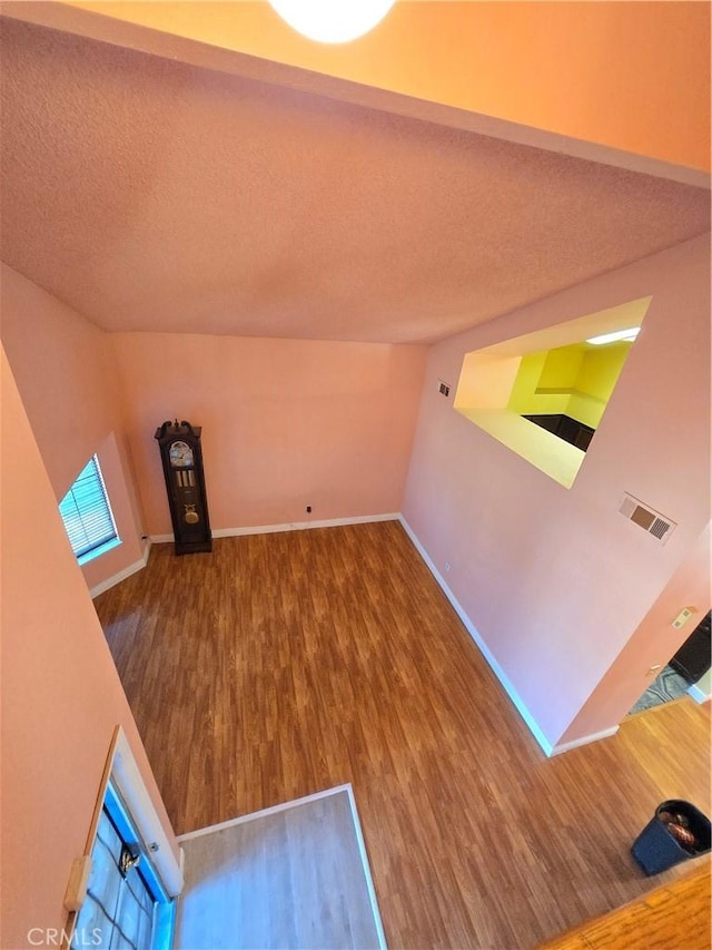 unfurnished living room with a textured ceiling and hardwood / wood-style floors