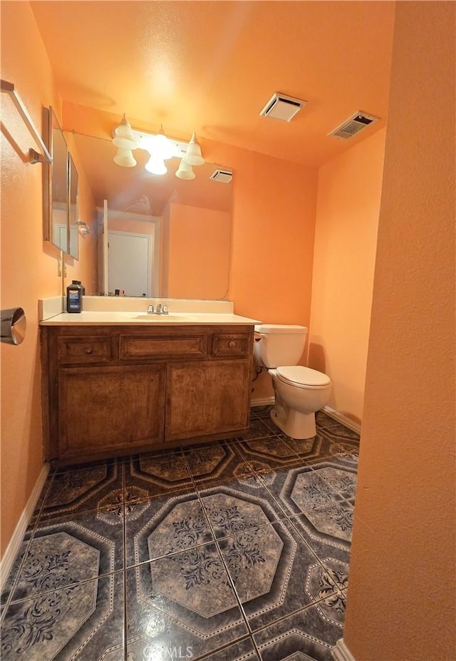 bathroom featuring toilet, vanity, and tile patterned flooring