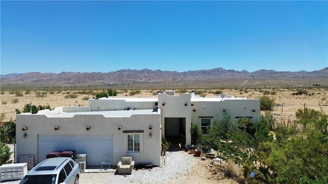 back of property with a mountain view and a garage