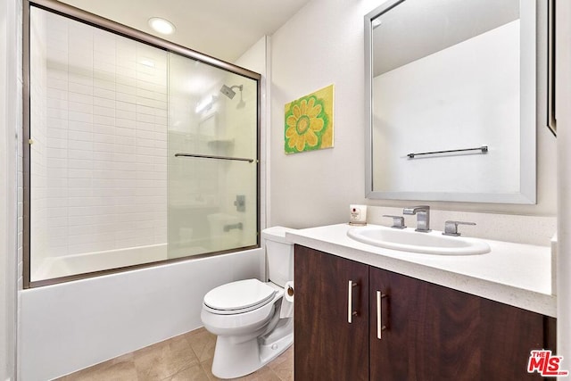 full bathroom with toilet, bath / shower combo with glass door, vanity, and tile patterned floors