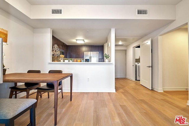 dining space featuring washer / dryer and light hardwood / wood-style floors