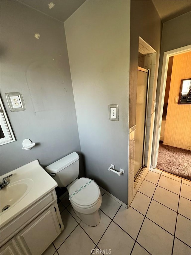 bathroom with walk in shower, vanity, tile patterned floors, and toilet