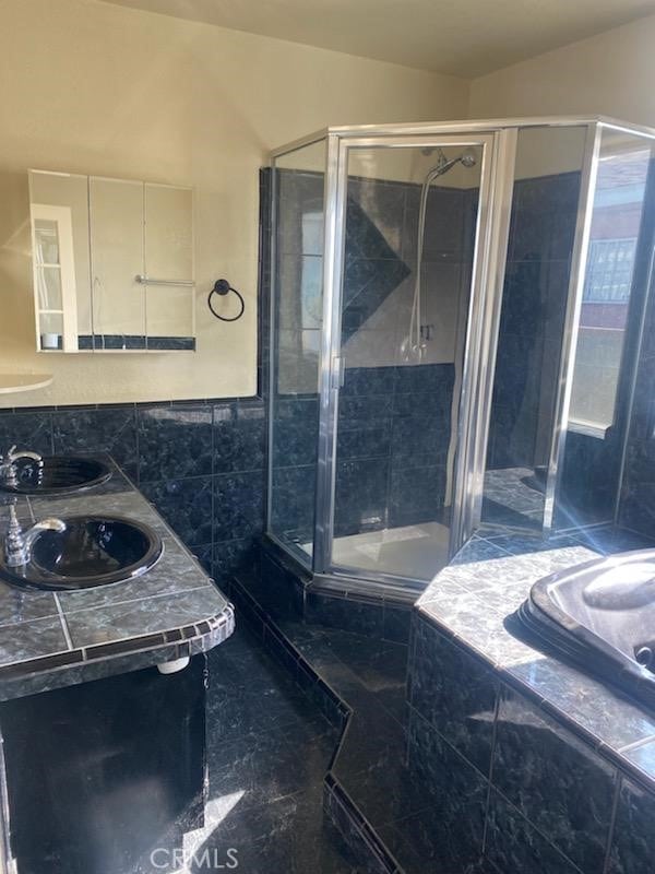 bathroom featuring sink and shower with separate bathtub