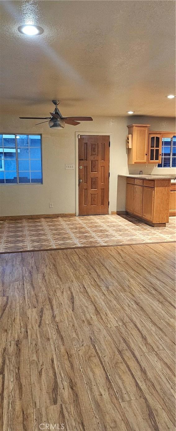 unfurnished living room featuring a textured ceiling and light hardwood / wood-style flooring