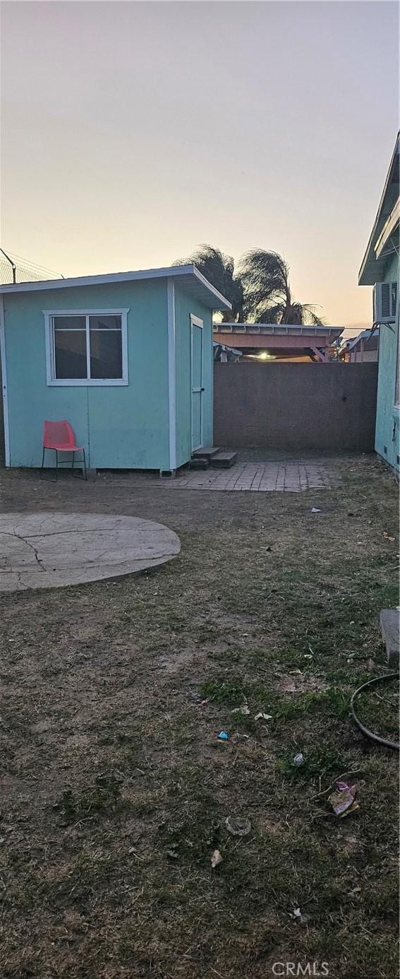 yard at dusk featuring an outbuilding