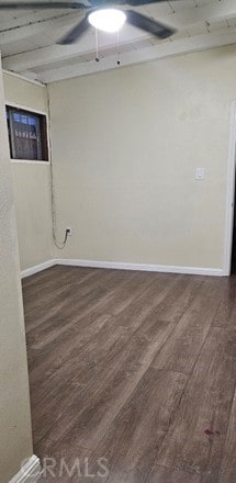 empty room with ceiling fan, dark wood-type flooring, and wooden ceiling