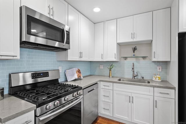 kitchen featuring stainless steel appliances, white cabinetry, and sink