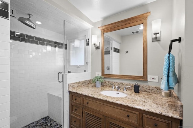 bathroom with vanity and a shower with shower door