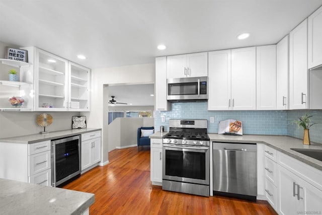 kitchen with ceiling fan, beverage cooler, white cabinets, and appliances with stainless steel finishes