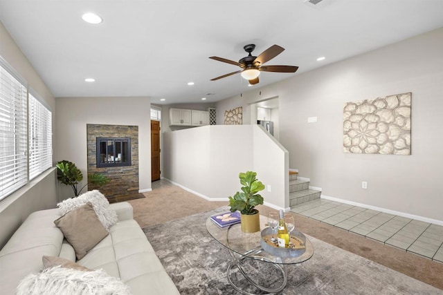 tiled living room featuring a fireplace and ceiling fan