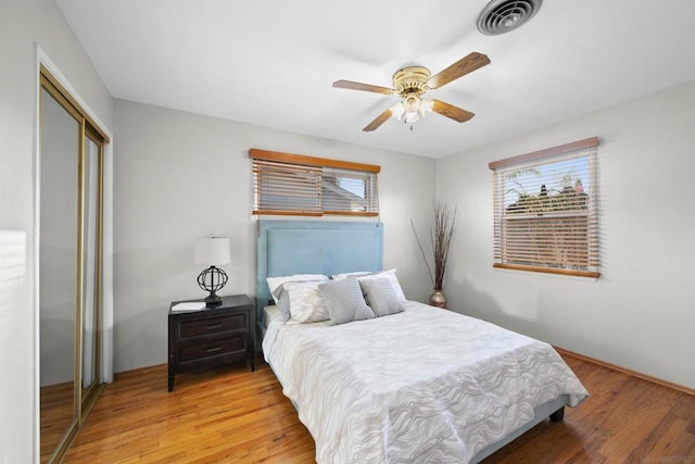 bedroom featuring wood-type flooring, ceiling fan, and a closet