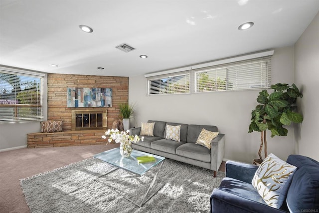 carpeted living room with a stone fireplace