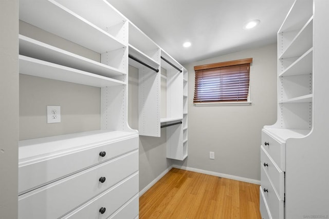 walk in closet with lofted ceiling and light hardwood / wood-style flooring