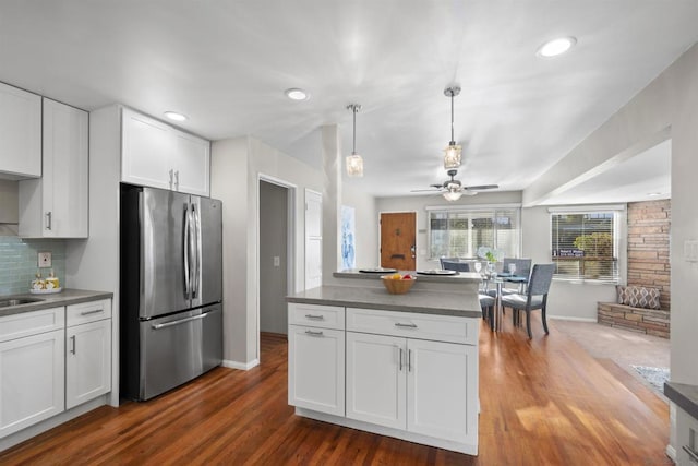 kitchen with tasteful backsplash, ceiling fan, stainless steel fridge, and white cabinets