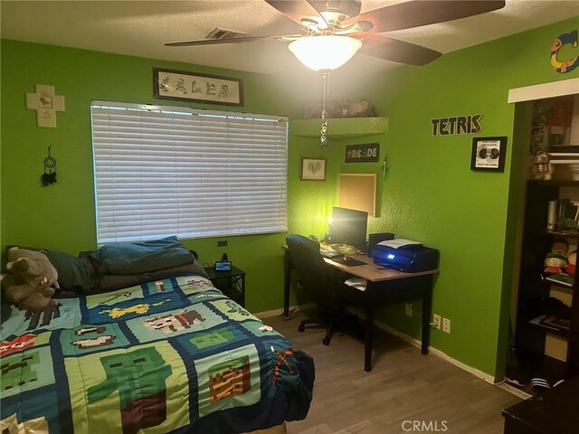 bedroom with ceiling fan and hardwood / wood-style floors