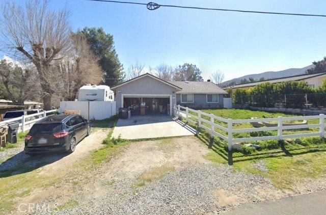 single story home featuring a mountain view, a garage, and a front yard