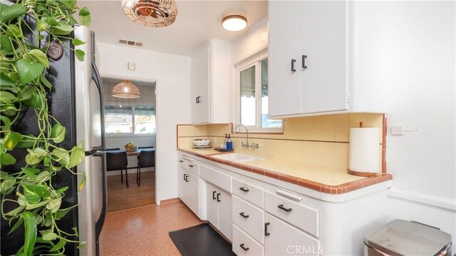 bathroom featuring sink, backsplash, and a wealth of natural light