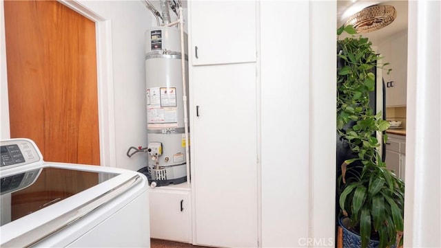 clothes washing area with strapped water heater and washer / clothes dryer