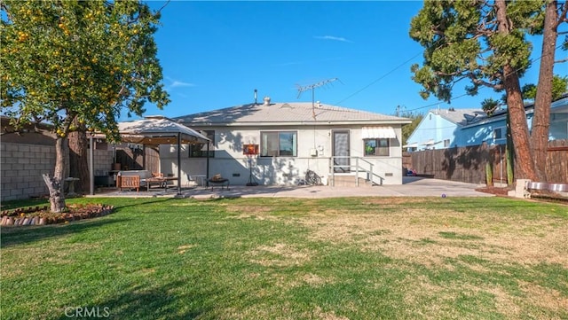 back of property featuring a gazebo, a yard, and a patio