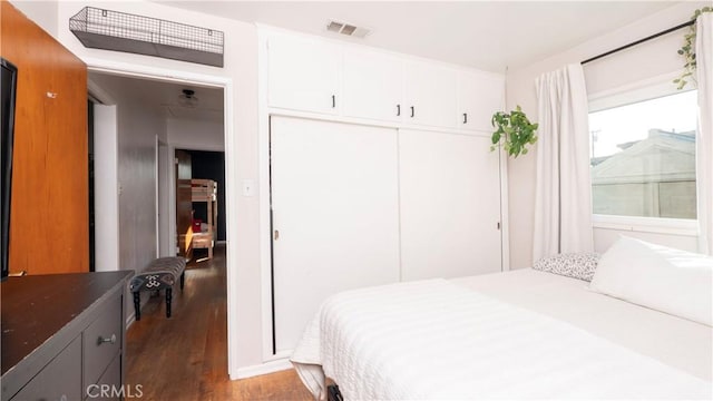 bedroom with wood-type flooring and a closet