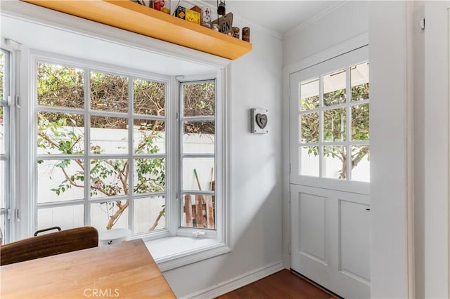 doorway to outside featuring dark hardwood / wood-style floors and crown molding